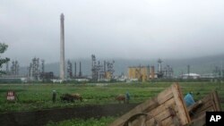 FILE - Farmers work their fields outside the Sungri Chemical Factory, an oil refinery in the Rason Special Economic Zone near North Korea's Russian and Chinese borders, July 23, 2016. 