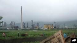 FILE - Farmers work their fields outside the Sungri Chemical Factory, an oil refinery in the Rason Special Economic Zone near North Korea's Russian and Chinese borders, July 23, 2016. 