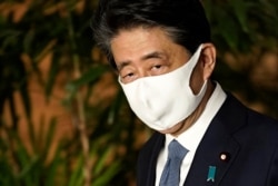 Japan's Prime Minister Shinzo Abe, wearing a face mask,walks after his press conference in Tokyo, Aug. 28, 2020.