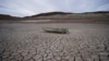 FILE - A formerly sunken boat sits on cracked earth scores of meters from the shoreline of Lake Mead at the Lake Mead National Recreation Area on May 10, 2022, near Boulder City, Nev. 