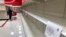 A woman looks at empty shelves in the paper goods section at a store in Overland Park, Kan., March 19, 2020. Stores struggle to keep shelves stocked with toilet paper, face masks, hand sanitizer and disinfectants.