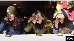 ຍານາອາລີນາ ອິນທາລີ ແລະນັກທ່ອງທ່ຽວ ກຳລັງຊີມອາຫານ ຢູ່ໃນນະຄອນຫຼວງລໍຊິງຕັນ.