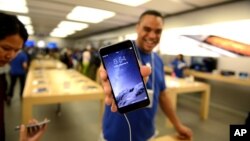 Un representante de Apple muestra un iPhone 6 en una tienda de Canadá.