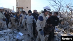 Nhân viên cứu hộ khiêng thi thể nạn nhân ra khỏi đống đổ nát của bệnh viện ở tỉnh Idlib, miền bắc Syria, sau vụ pháo kích ngày 15 Tháng 2, 2016.