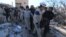 People and Civil Defense members carry a dead body removed from a destroyed Medecins Sans Frontieres (MSF) supported hospital hit by missiles in Marat Numan, Idlib province, Syria, Feb. 16, 2016. 