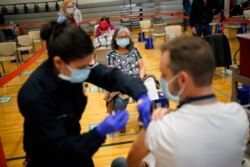 People receive the COVID-19 vaccine at a vaccination site Feb. 17, 2021, in Las Vegas.