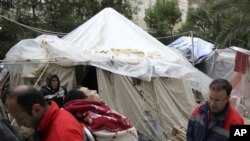 An immigrant from North Africa is carried away by paramedics at the Hypatia mansion in Athens, March 1, 2011