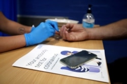 برطانیہ کی کیلی یونیورسٹی میں ایٹی باڈیز کے ٹیسٹ کے لیے ایک شخص کی انگلی میں سوئی چبھو کر خون کا نمونہ حاصل کیا جا رہا ہے۔ 20 جون 2020