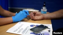 A man has his finger pricked during a clinical trial of tests for the coronavirus disease (COVID-19) antibodies, at Keele University, in Keele, Britain, June 30, 2020.