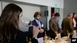 A woman tastes 2015 vintage wine from Barsac Sauternes during the Union des Grand Crus of Bordeaux tasting event Jan. 25, 2018, in San Francisco. 