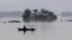 Indian villagers paddle a boat through floodwaters near partially submerged houses in Balimukh village in the Morigaon district of Assam state, Aug. 17, 2014. 