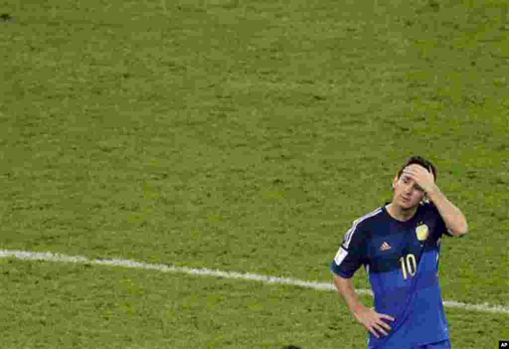 Argentina's Lionel Messi reacts as Germany's players celebrate after winning in extra time during the World Cup final soccer match between Germany and Argentina at the Maracana Stadium in Rio de Janeiro, Brazil, Sunday, July 13, 2014. Germany won 1-0. (AP