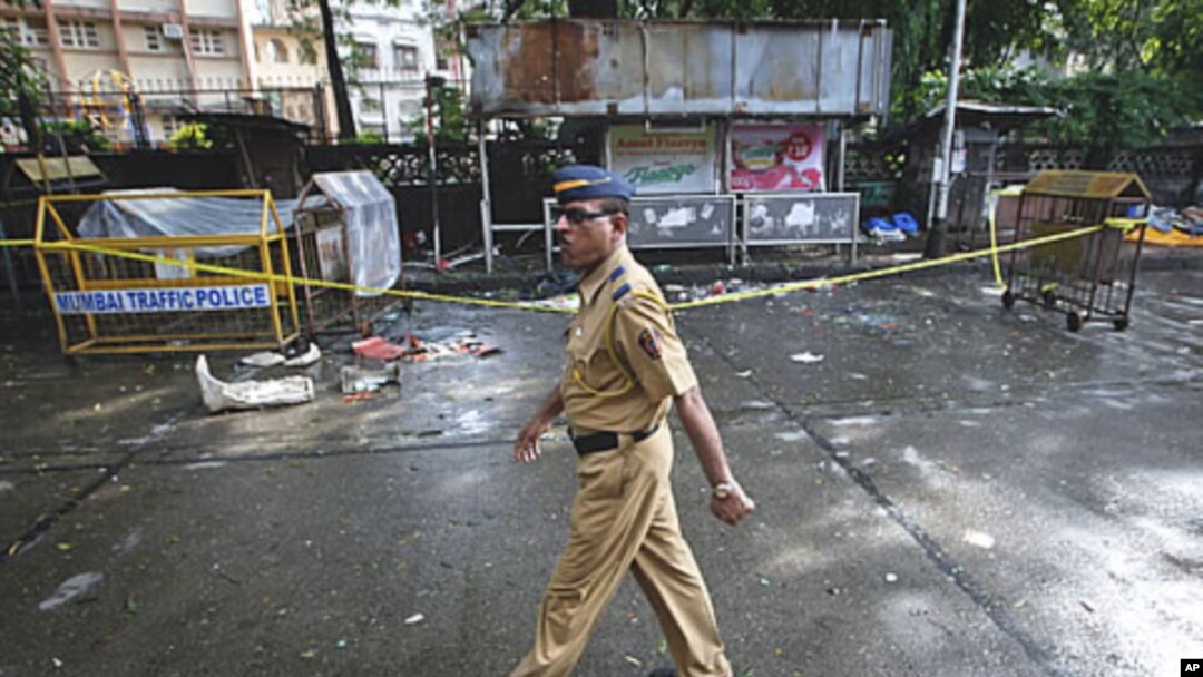 A policeman walks past the site of an explosion at Dadar in Mumbai, July 15, 2011