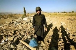 FILE - Pir Shah, from VOA’s Deewa Pashto service, in October 2008 in the Bajaur tribal area in Pakistan, standing in debris of a market place razed by the Pakistani military. (VOA/Pir Shah)