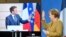 German Chancellor Angela Merkel waves to French President Emmanuel Macron at the end of a press conference following German-French Security Council video talks in Berlin, Germany, Feb. 5, 2021.