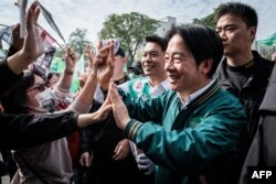 Wakil Presiden Taiwan dan calon presiden dari Partai Progresif Demokratik (DPP) yang berkuasa, Lai Ching-te (tengah) menyapa para pendukungnya selama tur iring-iringan kampanye di Kaohsiung pada 8 Januari 2024. (Foto: AFP)