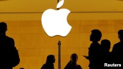 Clientes caminan delante de un logo de Apple en una tienda Apple en Grand Central Station, en Nueva York. Agosto 1, 2018.