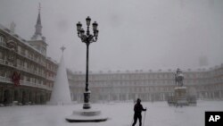 Žena na skijama prelazi glavni trg u Madridu za vreme snežne mećave u Španiji.