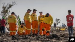 Para penyelidik memeriksa puing-puing pesawat Boeing 737 MAX 8 yang dioperasikan oleh Ethiopia Airlines yang jatuh di dekat Bishoftu atau Debre Zeit di selatan Addis Ababa, Ethiopia, 12 Maret 2019. (Mulugeta Ayene/AP)