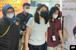 Alice Guo, mantan wali kota Filipina yang dituduh membantu mendirikan pusat perjudian daring dan penipuan ilegal, dikawal petugas imigrasi sebelum dideportasi di Jakarta, 5 September 2024. (Ditjen Imigrasi via AP)