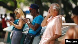 Cubans check their phones at an internet hotspot in Havana, Cuba, Aug. 10, 2018. A day of free, expanded internet was provided by the state-run telecommunications company on Aug. 14, 2018.