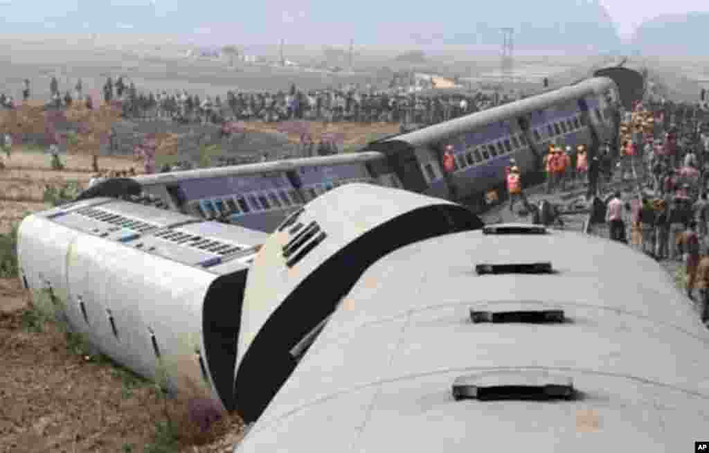 Onlookers and rescue workers gather around the derailed coaches of a passenger train in Bangapara village near the northeastern city of Guwahati February 3, 2012.