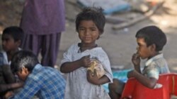 Indian street children eat food at a shanty town in Hyderabad