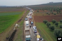 Civilians flee from Idlib to find safety inside Syria near the border with Turkey, Feb. 11, 2020.