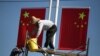 工人们在大街上悬挂中国国旗。