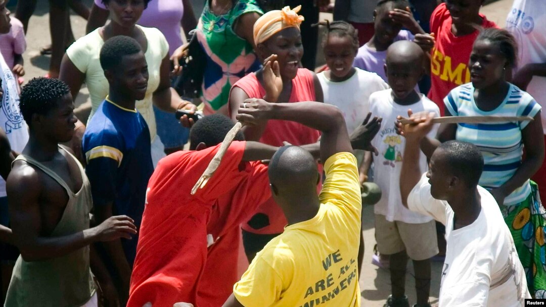 A youth is beaten with sticks after being accused of attempted theft in Monrovia, February 2007.