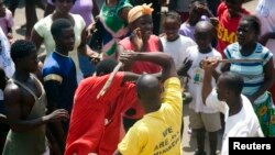 A youth is beaten with sticks after being accused of attempted theft in Monrovia, February 2007.