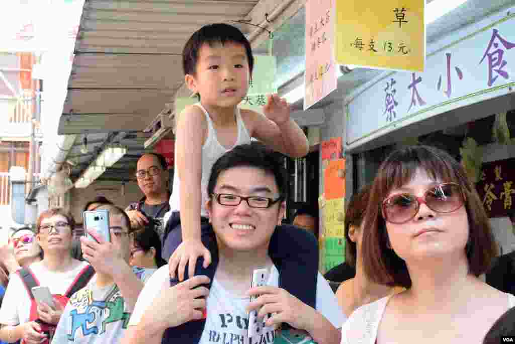家長帶同小朋友欣賞長洲太平清醮飄色巡遊。(美國之音記者湯惠芸拍攝)