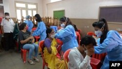 People get inoculated with a dose of the Covaxin Covid-19 coronavirus vaccine at a temporary vaccination camp inside a school in Mumbai on Sept. 6, 2021.