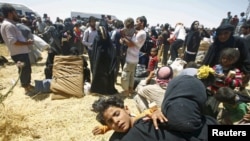 Para pengungsi Suriah menunggu transportasi setelah menyeberang ke Turki dari kota Tal Abyad, Suriah (10/6). (Reuters/Osman Orsal)