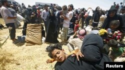 Syrian refugees wait for transportation after crossing into Turkey from the Syrian town of Tal Abyad, near Akcakale in Sanliurfa province, Turkey, June 10, 2015.