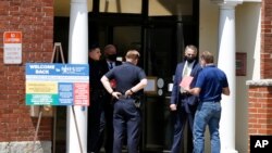 A job seekers receives a timed entry card as he enters the New Hampshire Works employment security job center, May 10, 2021, in Manchester, N.H. 