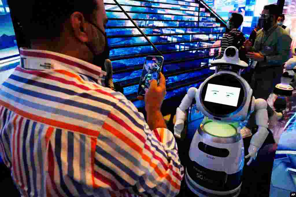 در همایش فناوری جی آی تی ای اکس که در دوبی برگزار شد مردی از یک روبات عکس می‌گیرد.