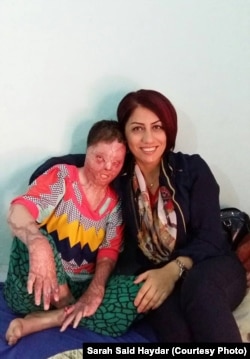 Sarah Said Haydar, left, shown here with a Yazidi activist, suffered burns over more than half her body in a suicide attempt.