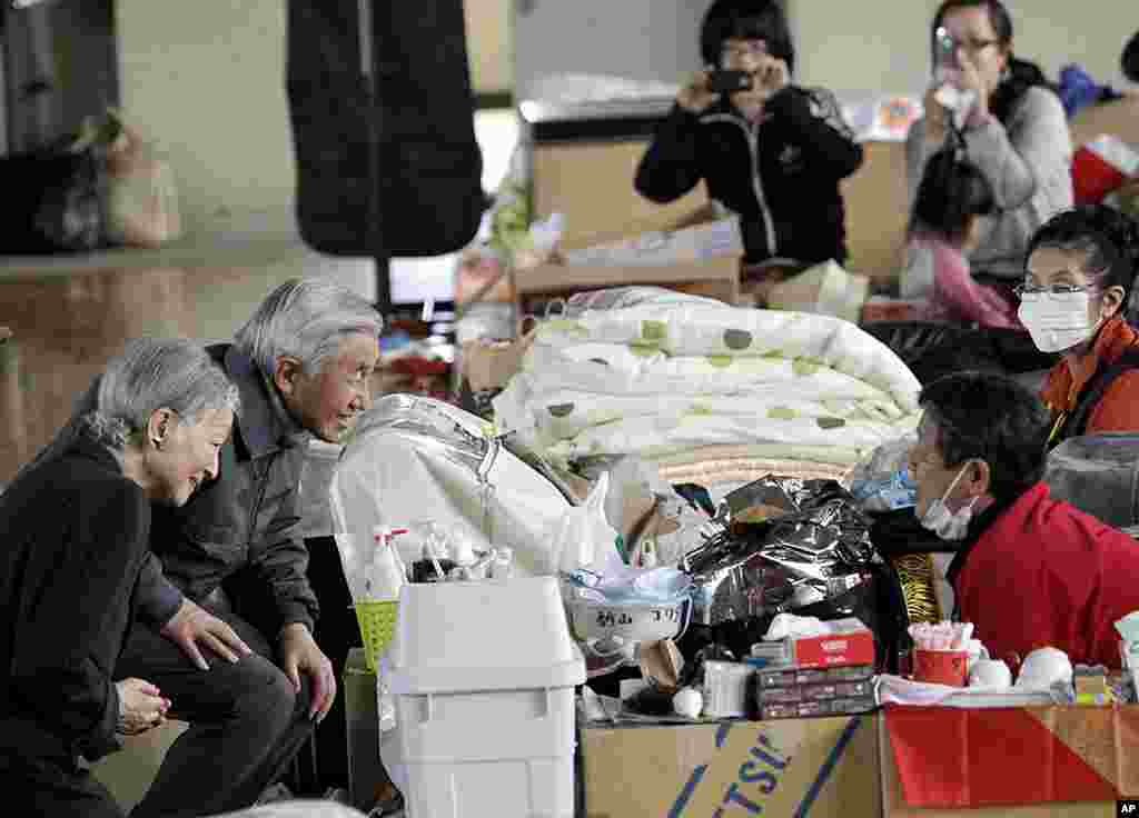 Japan&#39;s Emperor Akihito, second from left, and Empress Michiko, left, talk with an evacuee at an evacuation center in Kazo, Saitama Prefecture, April 8, 2011. 