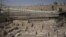 Members of the media and workers from Israel's antiquity authority stand at a site that archaeologists say contains the remnants of an ancient Greek fortress, outside the walled Old City of Jerusalem, Nov. 3, 2015. 