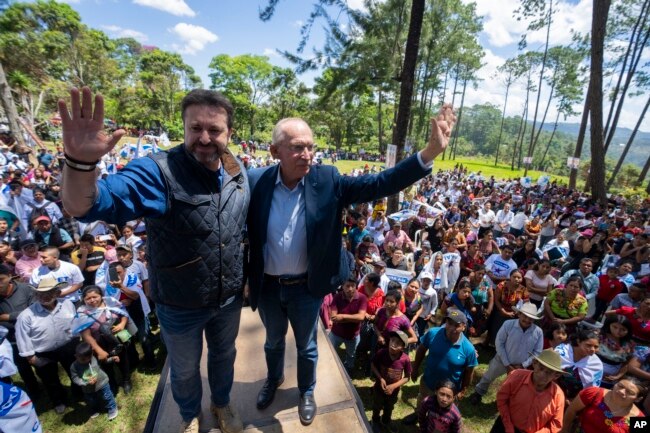 Edmond Mulet, candidato presidencial del partido Cabal, a la derecha, y su candidato a vicepresidente Max Santa Cruz posan para fotos durante un acto de campaña en San Juan Sacatepéquez, Guatemala, el domingo 18 de junio de 2023. Los guatemaltecos acuden a las urnas el 25 de junio. (Foto AP/Moisés Castillo)