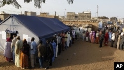 File d'attente des électeurs devant un bureau de vote du quartier Guediawaye, à Dakar. (Archive AP)