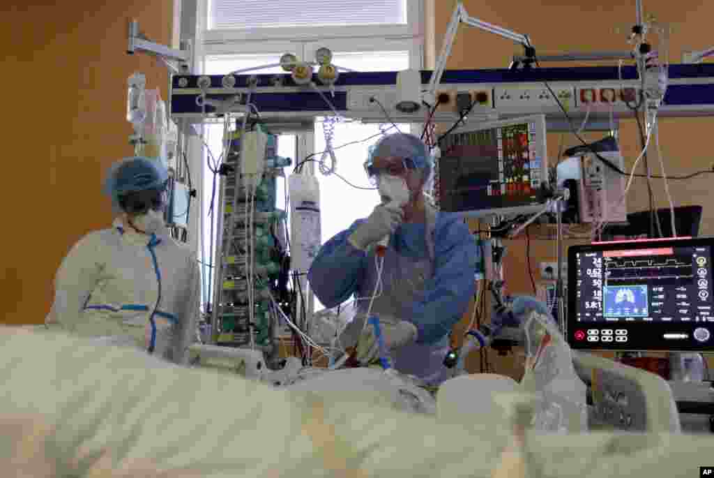 Healthcare workers attend to a COVID-19 patient at an intensive care unit (ICU) at the General University Hospital in Prague, Czech Republic.