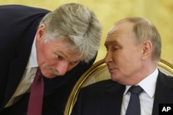 Presiden Rusia Vladimir Putin, kanan, berbicara dengan juru bicara Kremlin Dmitry Peskov dalam pertemuan puncak para kepala negara Persemakmuran Negara-negara Merdeka (CIS) di Kremlin, Moskow, 8 Oktober 2024. (Sergei Ilnitsky/Pool Photo via AP)