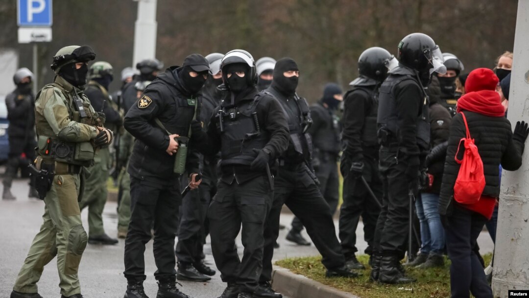 Para petugas keamanan Belarus menyaksikan para demonstran berdemo menolak hasil pilpres di Minsk, Belarus, Minggu, 22 November 2020. (Foto: Reuters)