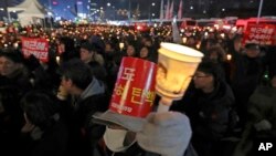 Protesters hold signs and candles during a rally demanding the resignation of South Korean President Park Geun-hye in Seoul, South Korea, Dec. 31, 2016. 