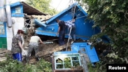 Cư dân địa phương dọn dẹp đống đổ nát do lũ lụt ở thị trấn Krymsk, miền nam nước Nga, 8/7/2012