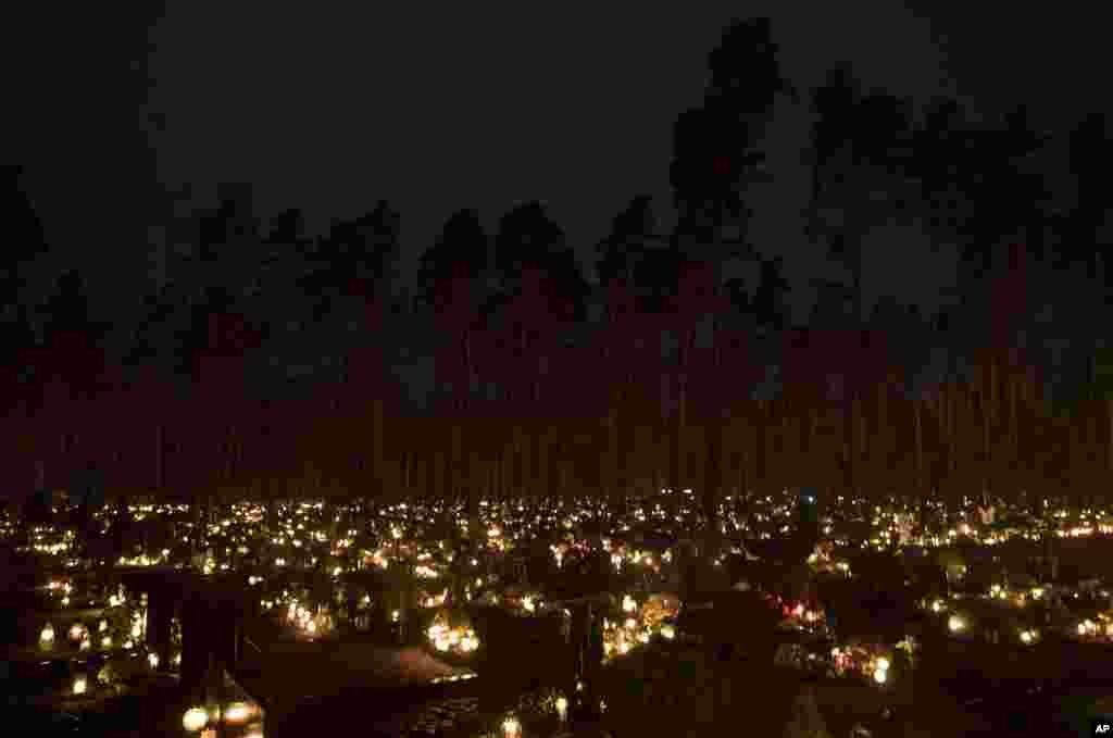 Candles are lit during All Saints Day at the cemetery in Vilnius, Lithuania, Nov. 1, 2017.