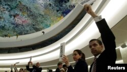 参加联合国人权理事会会议的代表举手要求发言。（2013年2月28日）