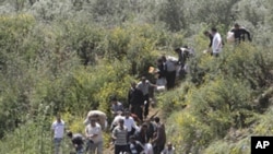 Syrian citizens carry their belongings, as they cross the border illegally , fleeing from violence the western Syrian village of Talkalakh, in the Wadi Khaled area, about one kilometer (0.6 miles) from the Lebanon-Syria border, north Lebanon, May 16, 201